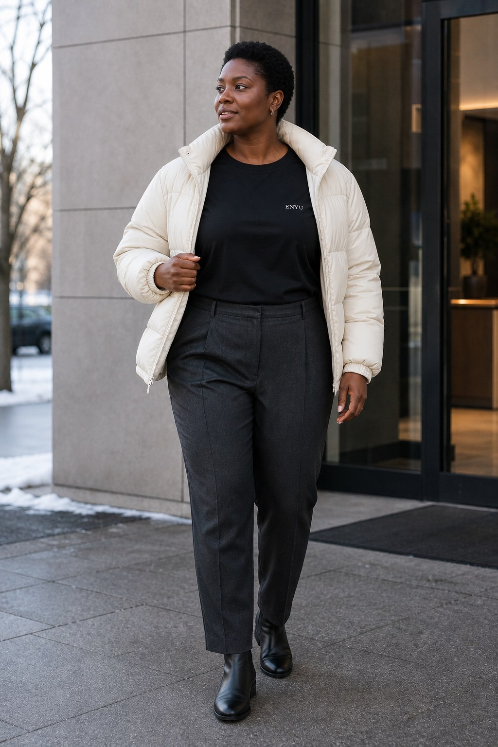 Creative editorial visual of a woman wearing a black ENYU short-sleeve Tee beneath an open ivory puffer in winter